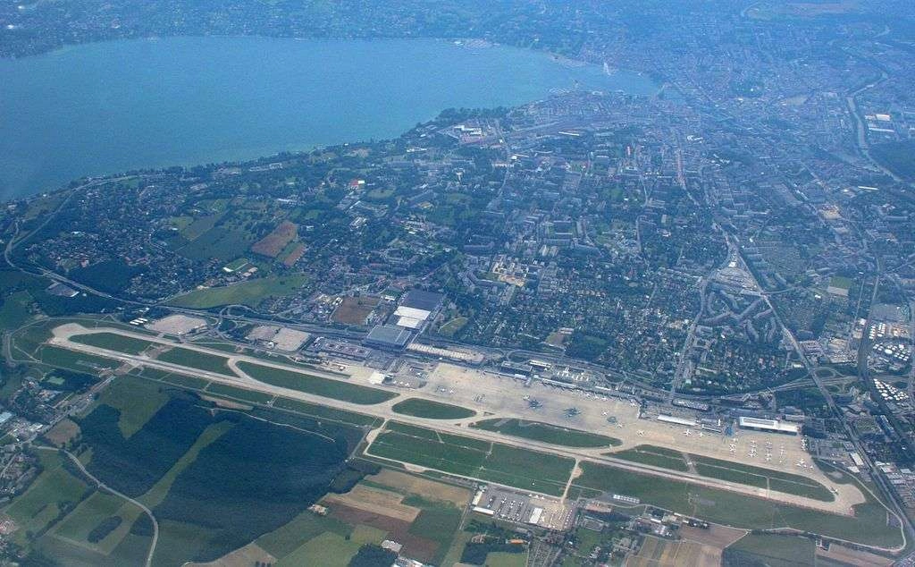 Geneva Airport aerial view showing the runway, terminal and surrounding city area